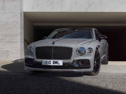 A grey bentley parked in a parking garage.