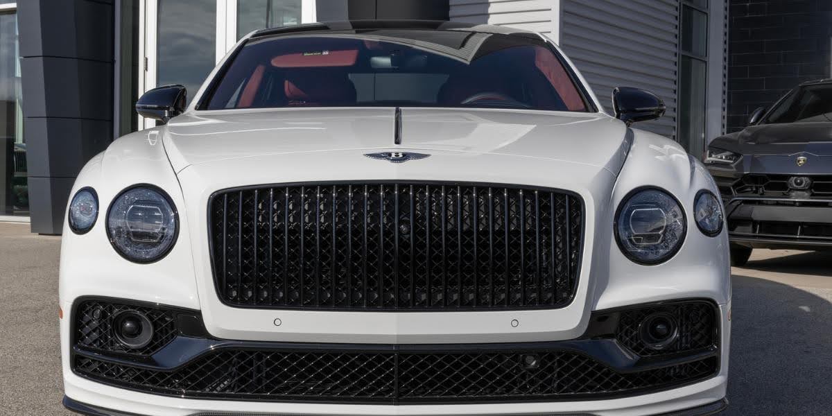 Close-up of the classic Bentley grille and headlight design, highlighting the elegance of a vehicle equipped with a W12 engine.